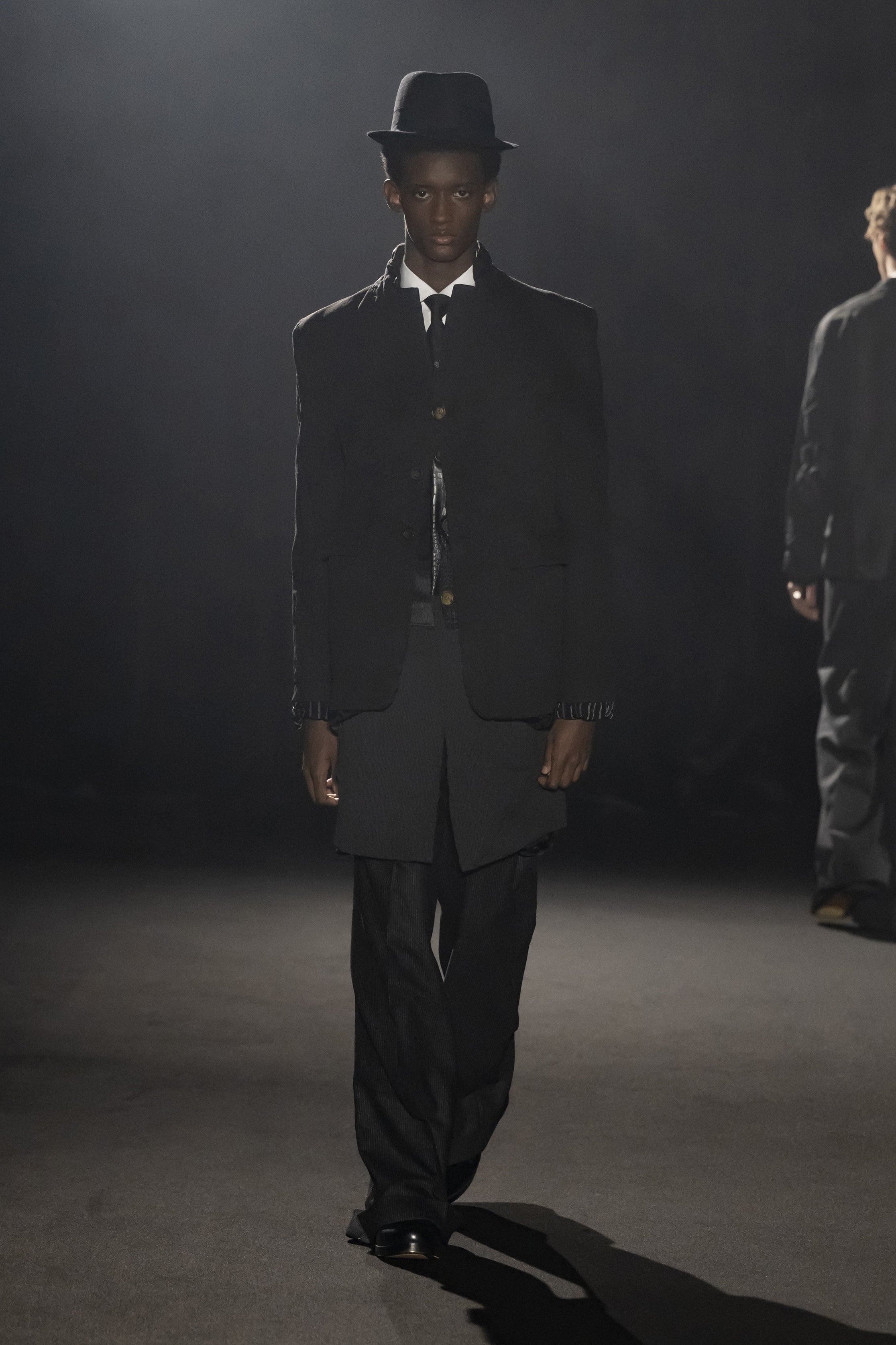 Fashion model wearing a JUNYA WATANABE MAN AW26 outfit