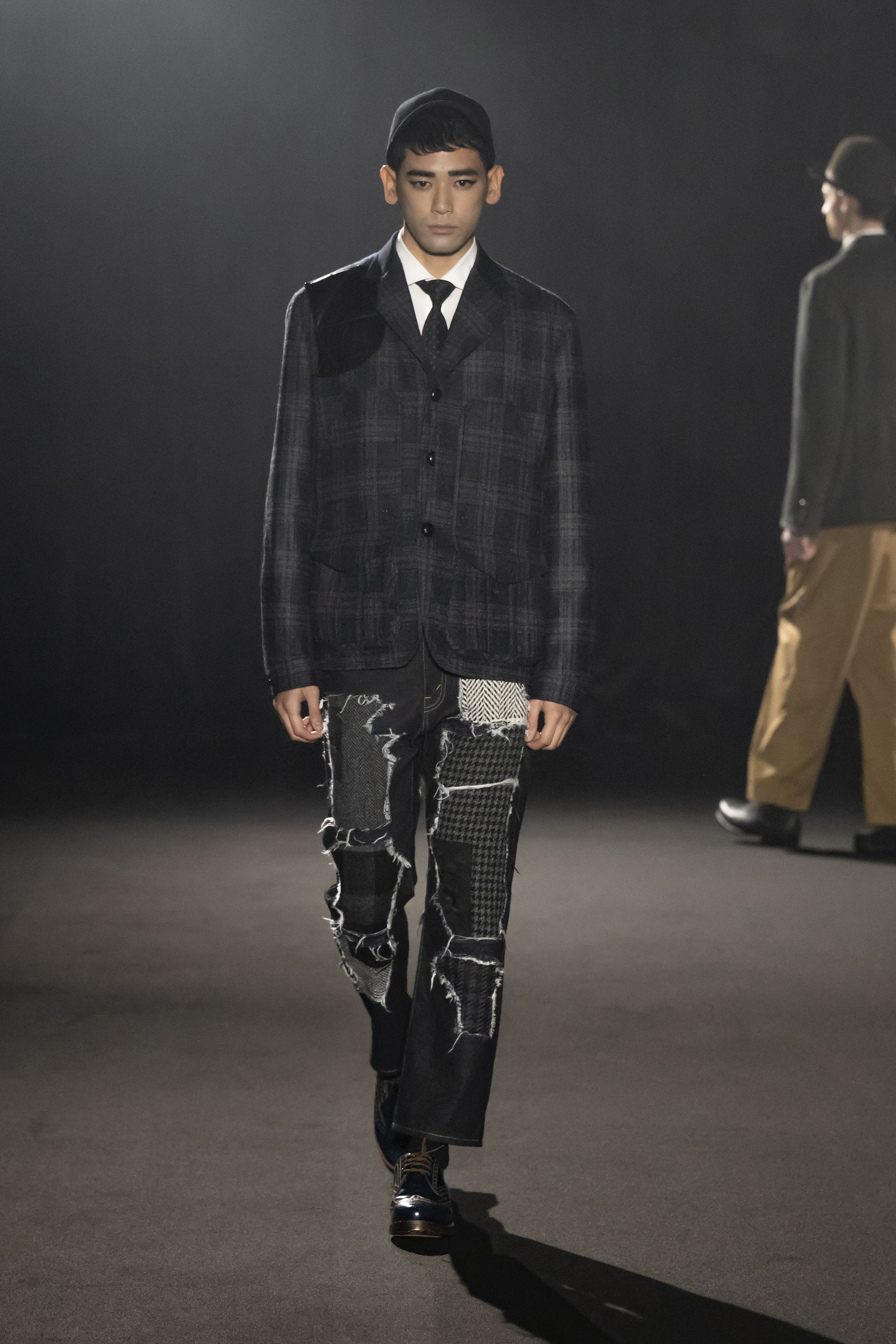 Fashion model wearing a JUNYA WATANABE MAN AW26 outfit