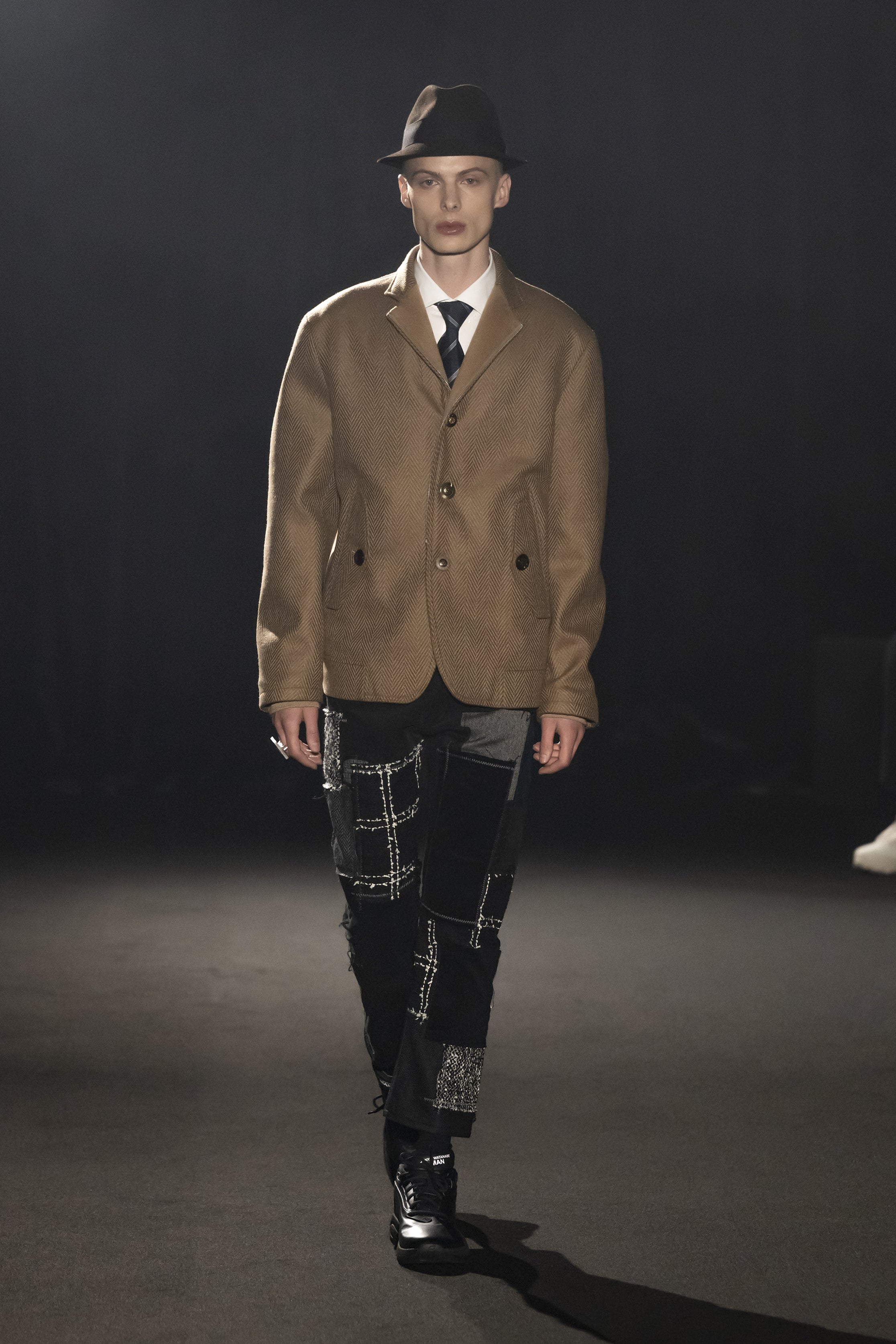 Fashion model wearing a JUNYA WATANABE MAN AW26 outfit